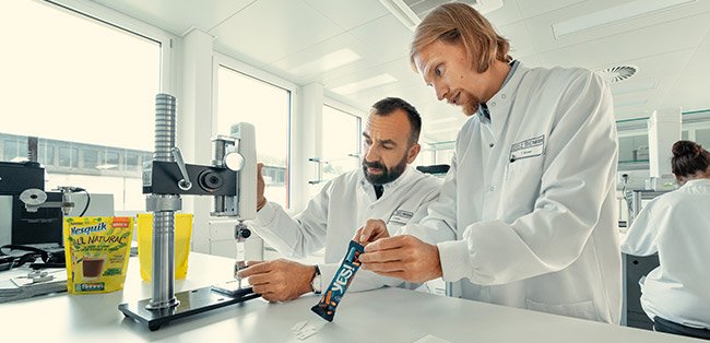 Tecnici al lavoro con camici bianchi in un laboratorio di ecodesign Nestlé