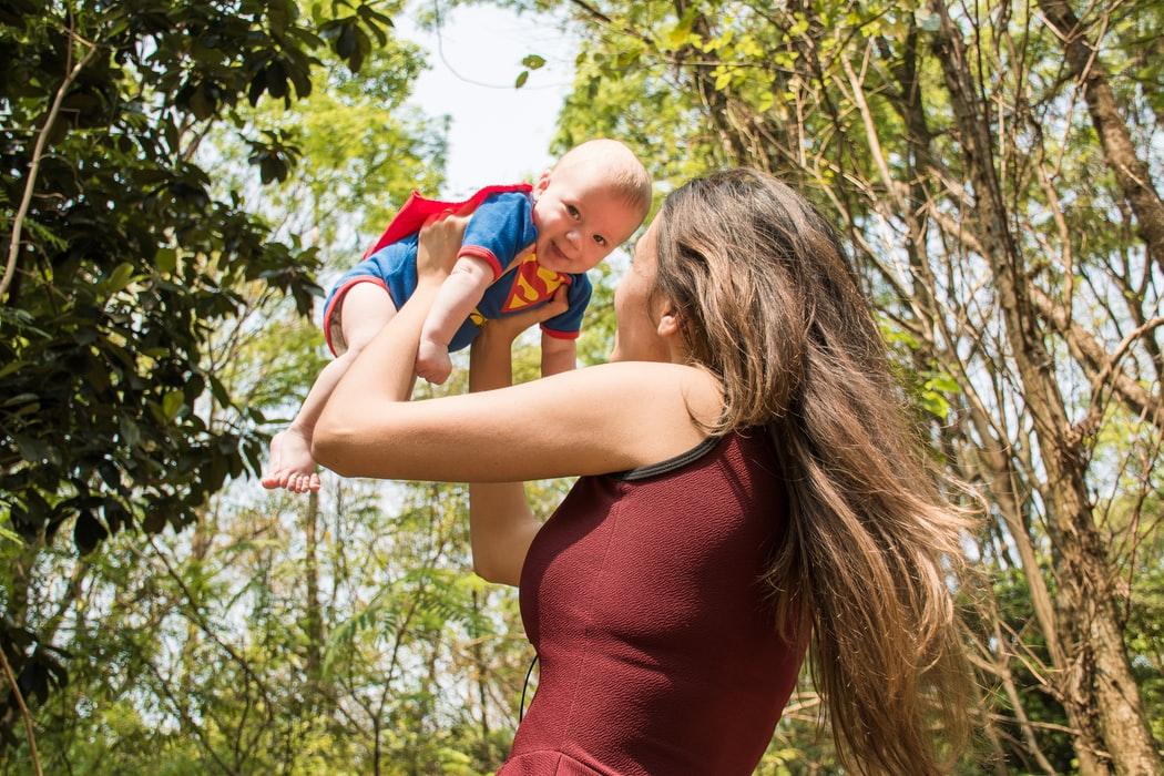 Mamma tiene in braccio il bimbo vestito da superman 