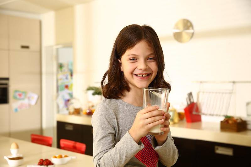 Una bimba che beve un bicchiere di latte