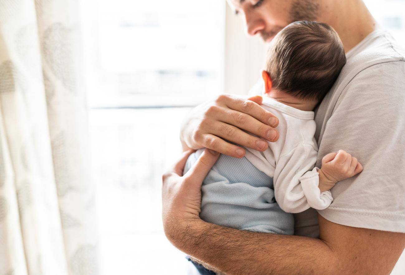 Padre che tiene in braccio il figlio neonato