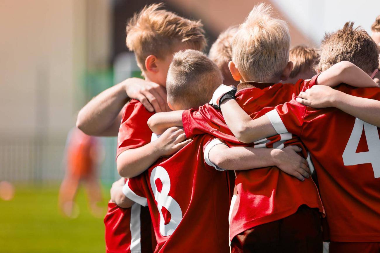 Bambini che si abbracciano su un campo da calcio