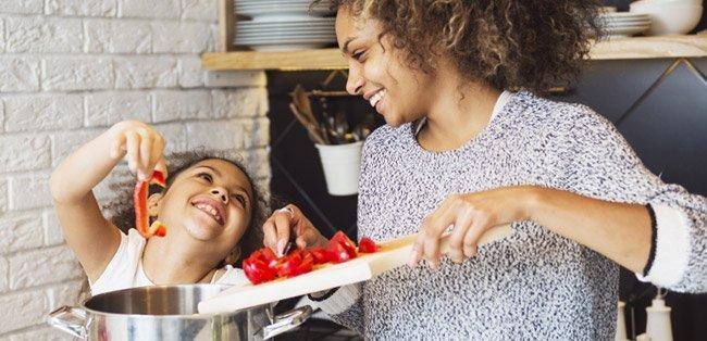 mamma e bambina cucinano i peperoni insieme