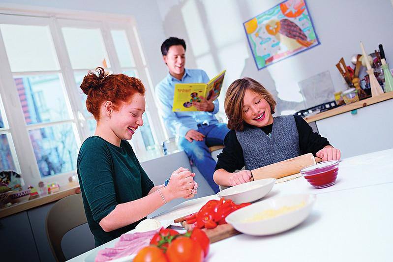 Due giovani in cucina che recuperano cibi e pietanze avanzate da Ferragosto
