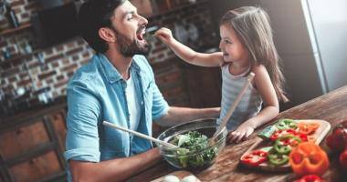 Una bambina che cucina e gioca con il suo papà