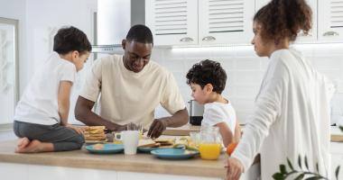 Una famiglia con due bambini che fanno colazione