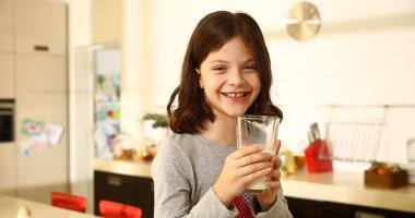 Una bimba che beve un bicchiere di latte