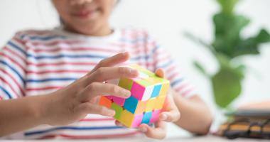 Bambina gioca con un cubo di Rubik