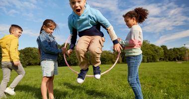 Bambini che giocano con un hula hoop sul prato