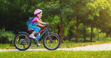 Bambina sorridente in bicicletta al parco