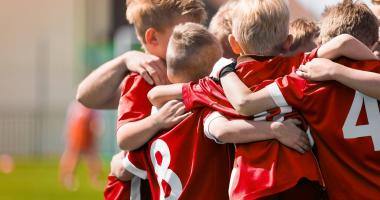 Bambini che si abbracciano su un campo da calcio