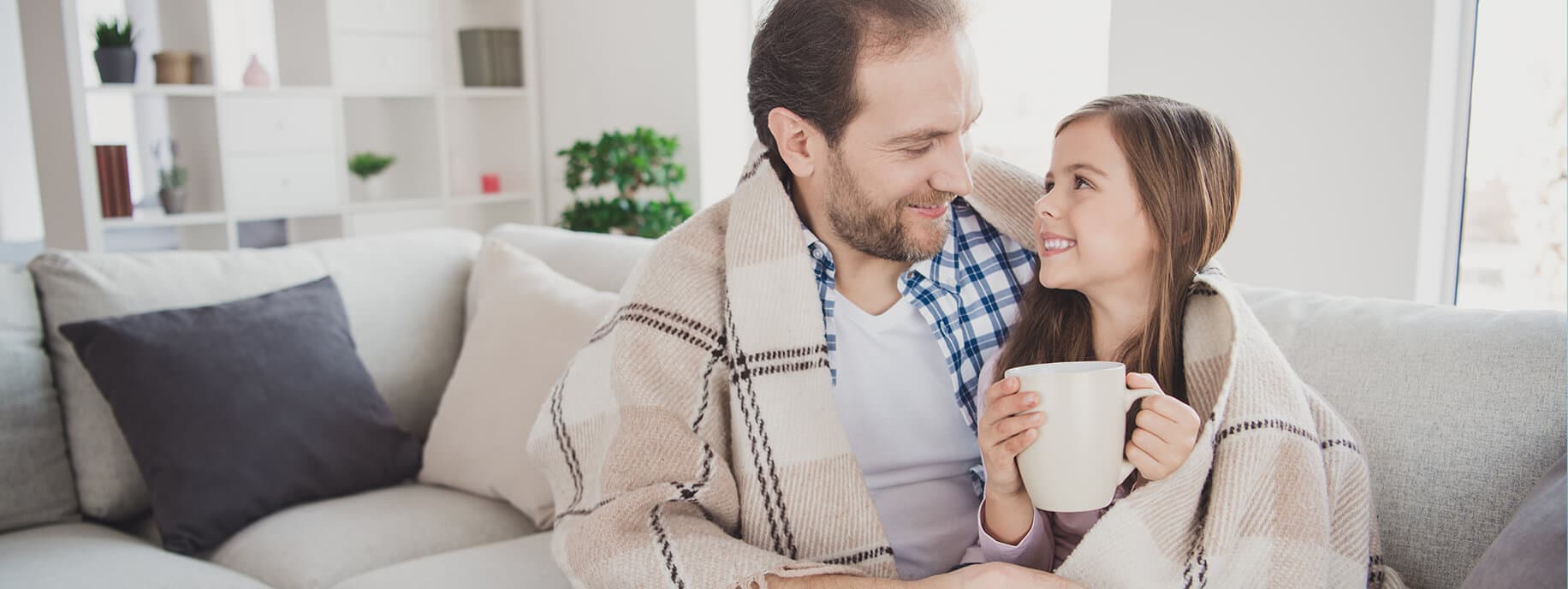 Papà e figlia con la copertina sul divano