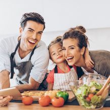 Famiglia felice cucina insieme a casa