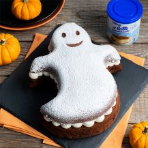Torta a forma di fantasmino sul tavolo contornato da zucche di Halloween e confezione di latte condensato Nestlé