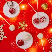 Cake Pops di Natale su tovaglia rossa e decorazioni natalizie