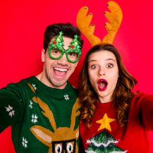 Ragazzo e ragazza con maglione occhiali e orecchie natalizie