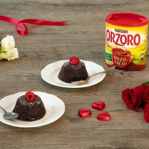 Due tortini al cioccolato su piatti bianchi con confezione di Orzoro al cacao accanto