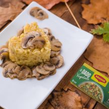 Risotto impiattato a forma di cuore con champignon intorno e confezione dado Maggi accanto