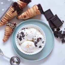 3 coni gelato di sfoglia sul tavolo con pezzi di cioccolato e ciotola con gelato accanto