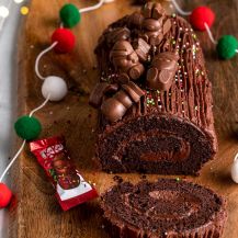 Tronchetto di Natale con Kitkat su piatto e decorazioni natalizie