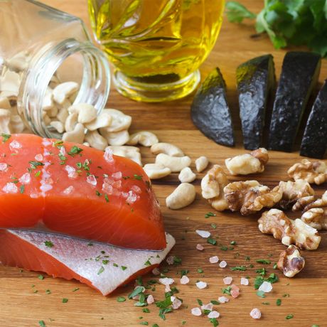 Salmone, pinoli, olio di oliva e noci sulla tavola