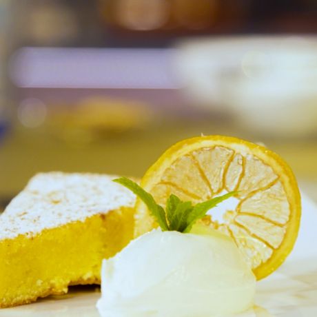 Fetta di caprese al limone decorata con panna e foglie di menta