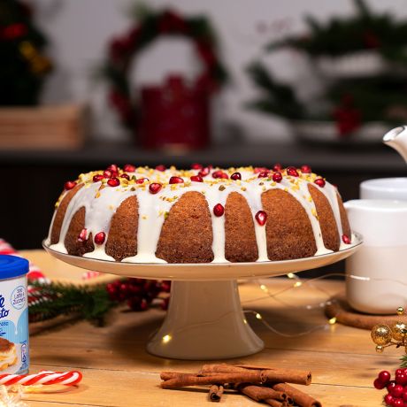 Gingerbread Bundt Cake su alzatina bianca in tavola natalizia e confezione di latte condensato Nesltè accanto