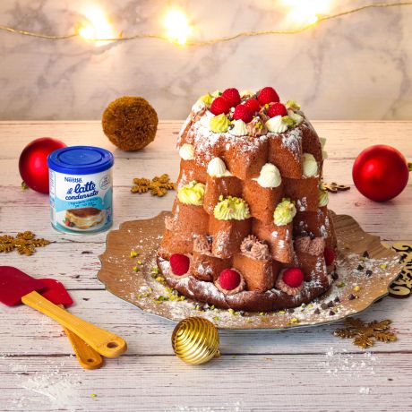 Pandoro farcito con decorazioni di frutti rossi e palline di natale