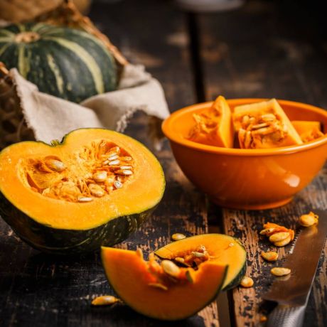 Zucca tagliata a metà e pezzi di zucca su un tavolo 