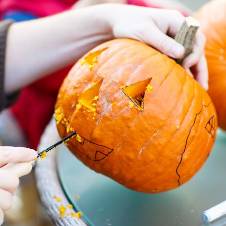 Bambino che intaglia una zucca per la festa di halloween