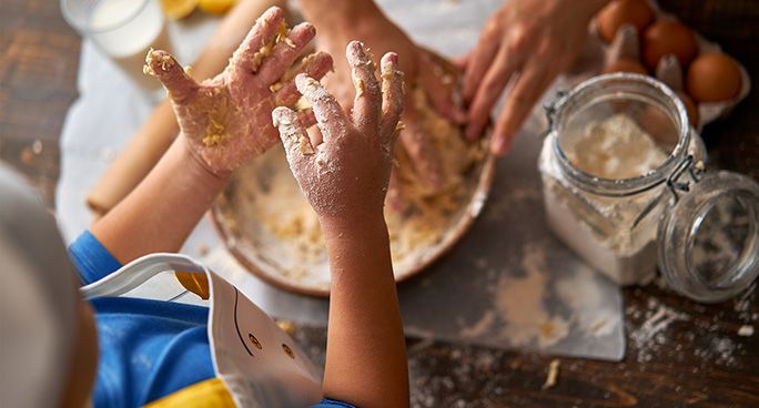 Bambino impasta gli ingredienti per cucinare dei biscotti al cocco fatti in casa