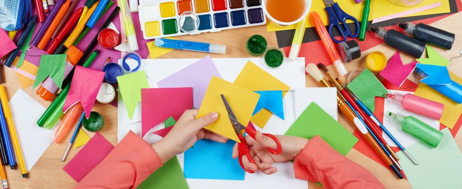 Quali lavoretti per bambini dai 4 agli 6 anni? Bambina che ritaglia fogli colorati