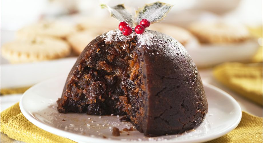 Pudding tagliato su piatto bianco in una tavola natalizia