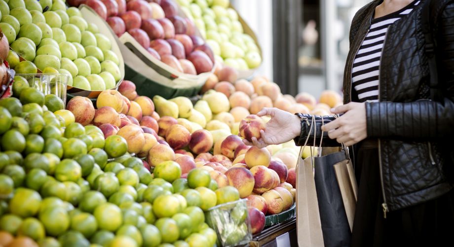 Giovane donna acquista frutta al supermercato