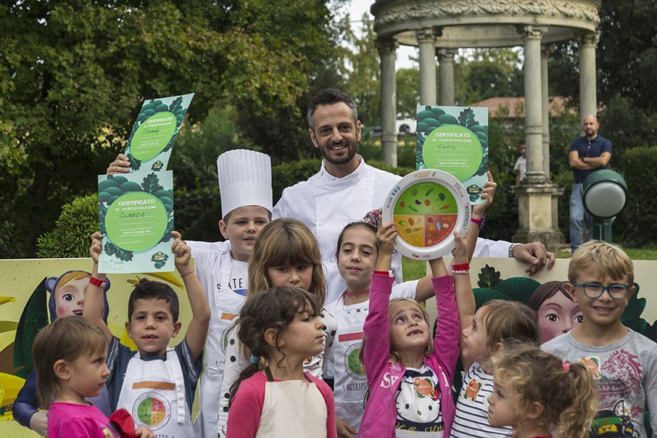 Bambini felici all'aperto insieme a chef mostrano certificato