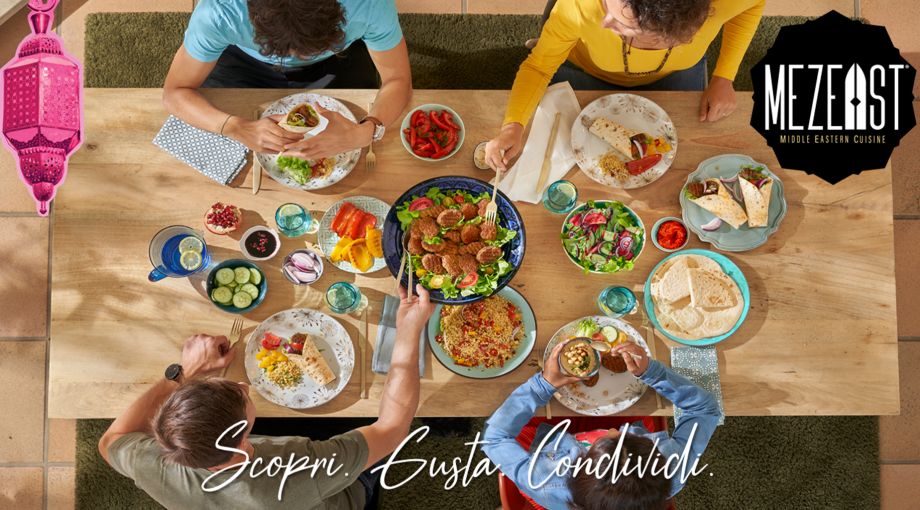 Scopri i nuovi prodotti Mezeast tavola dall'alto con prodotti Mezeast e persone che condividono il pasto